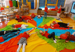 dzieci na leżąco bawią się balonami